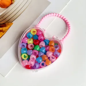 Boîte de rangement transparente en forme de cœur avec pinces à cheveux mini colorées.