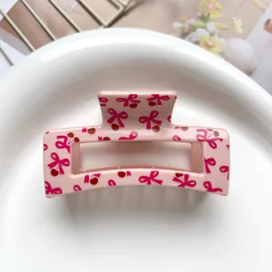 Pink hair claw clip featuring sweet bow and cherry print, perfect for cute everyday hairstyles.