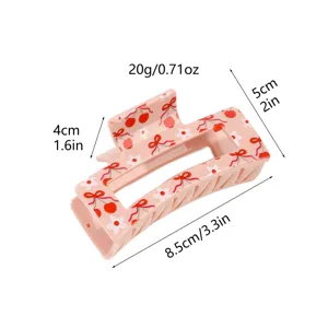 Pink hair claw clip with cute cherry bow pattern, stylish rectangular design for women.