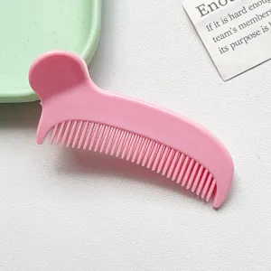 Dettaglio clip per pettine per capelli in plastica rosa, strumento di styling portatile.