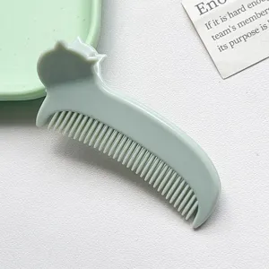 Dettaglio in primo piano del pettine per capelli portatile verde chiaro con orecchie.