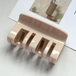 Detail view of a minimalist beige PC hair claw clip, elegant hair accessory for styling.
