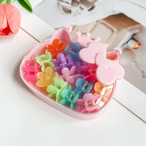 Gros plan détaillé de mini pinces à cheveux colorées bien rangées dans une jolie boîte rose.