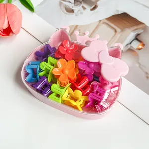 Gros plan de mini pinces à cheveux colorées en forme de fleur dans une boîte rose détail