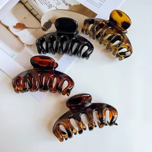 Detailed view of large glossy amber hair claw clips, perfect for thick hair styling accessories.