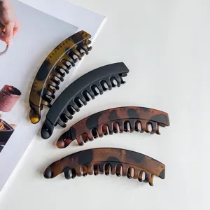 Detail view of stylish leopard and tortoiseshell banana hair clips, perfect for daily styling.