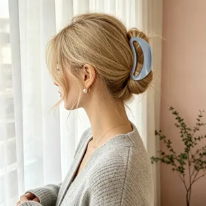 Close-up detail view of a chic greyish-blue geometric hair claw clip worn securely on styled hair.