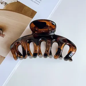 Glossy tortoiseshell hair claw clip, elegant acrylic hair catcher for thick hair styling.