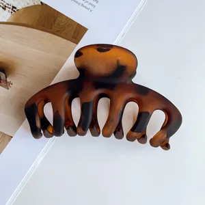 Matte tortoise shell hair claw clip for women stylish half up updo hair styling accessory.