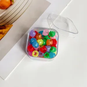 Ensemble de mini pinces à cheveux colorées dans une boîte de rangement transparente.