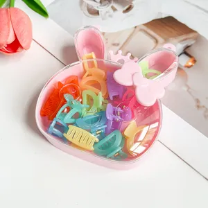 Vue détaillée d'une jolie boîte de rangement rose lapin remplie de mini pinces à cheveux colorées.
