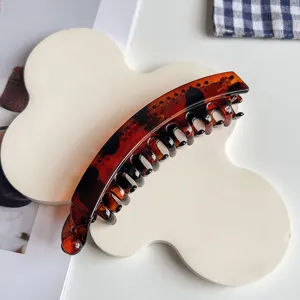 Leopard print banana hair clip detail, stylish resin tortoiseshell hair claw for styling.