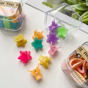 Detailansicht von bunten Mini-Stern-Haarklammern und geometrischen Clips in transparenten Boxen.