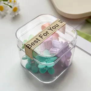 Detailaufnahme einer transparenten Box mit bunten Mini Blumen Haarklammern für Kinder.