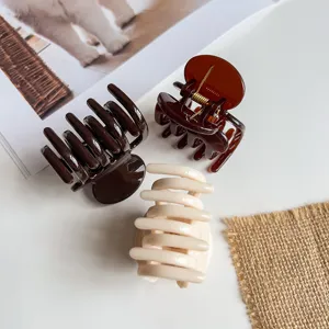 Detailoverzicht van drie kleine minimalistische haarclips in neutrale tinten voor dagelijks gebruik.