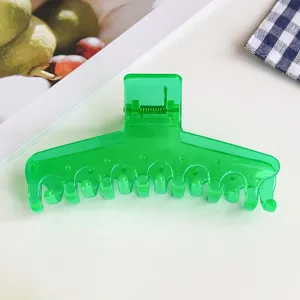 Grüne transparente T-förmige Haarklammer Detail, glänzender Kunststoff Haargreifer für dickes Haar.