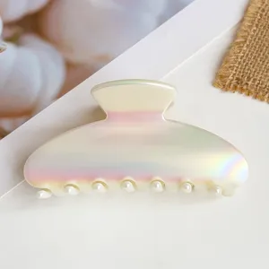 Primo piano dettagliato della molletta per capelli perlata con denti di perla su fondo bianco.