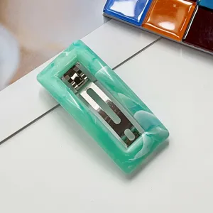 Green marble resin hair clip detail view, elegant rectangular barrette with secure metal clasp.