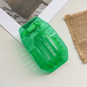 Close-up detail of a transparent green hollow flat hair claw clip, simple daily styling accessory.