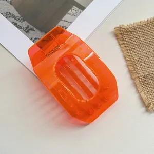 Transparent orange geometric hair claw clip, large hollow oval shark clip for women styling.