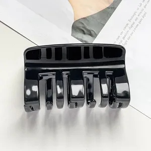Black glossy hair claw clip for women, simple PC plastic hair styling accessory detail shot.