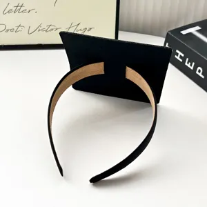 Graduation cap headband detail shot, black hair hoop with mini mortarboard design, photo prop.