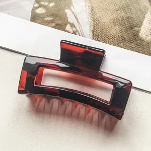 Braune Acryl Haarklammer Detail, elegante geometrische Haarspange fuer taegliches Haarstyling.