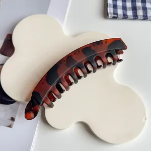Detail shot of the stylish leopard print banana hair clip, showing the curved comb teeth design.