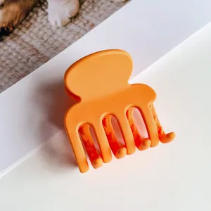 Matte orange kleine Haarklammer mit vier Zähnen für stilvolle hohe Pferdeschwänze Frisuren.