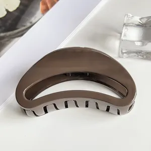 Brown crescent hair claw clip detail, elegant glossy resin hair accessory for women styling.