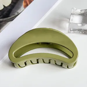 Close up view of a sleek olive green curved hair claw clip, perfect for styling up dos.