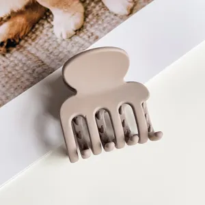 Kompakter matter Haargreifer in neutralem Nudeton, ideal für schicke Alltagsfrisuren.