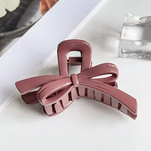 Close-up detail of the elegant mauve bow hair claw clip, showing glossy finish and spring.