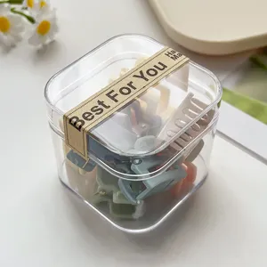 Detailansicht von Mini-Haarklammern in einer klaren Box, süße bunte Haar-Accessoires für Styling.