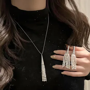 Elegant pearl tassel necklace and earrings set with shimmering zirconia accents for women.