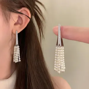 Detailed view of french zircon triangle pearl tassel stud earrings, elegant light luxury style.