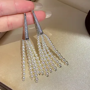 Detailed close-up display of stunning silver-tone triangle zircon pearl tassel earrings.