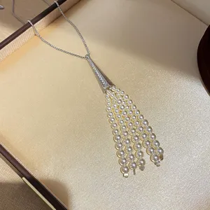 Elegant pearl tassel pendant necklace with shimmering zircon and delicate silver chain design.