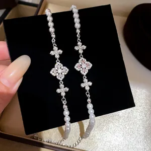 Detail view of pearl clover bracelet with sparkling cubic zirconia crystals for elegant women.
