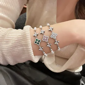 Elegant four-leaf clover pearl bracelet set with sparkling cubic zirconia for women.