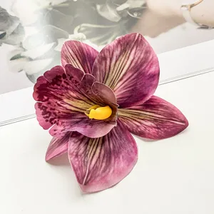 Detailaufnahme einer leuchtend lila künstlichen Orchideenblüten-Haarspange im Urlaubsstil.