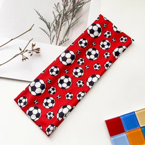 Detailed closeup of red soccer pattern elastic sports headband for sweat absorption.