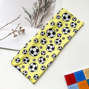 Close-up detail of the yellow elastic sports headband featuring classic black and white soccer pattern.