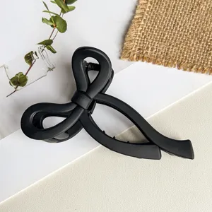 Detailaufnahme der mattschwarzen Haarklammer mit elegantem verschlungenem Schleifendesign.