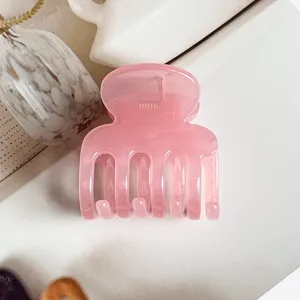 Pink translucent jelly hair claw clip detail shot, elegant daily hair styling accessory.