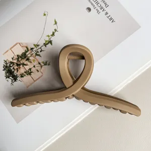 Nahaufnahme einer matten Beigen Kreuz Haarklammer, Premium dickes Design für elegante Frisuren.