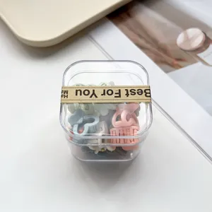 Joli ensemble de mini pinces à cheveux dans une boîte transparente avec des motifs pastel.