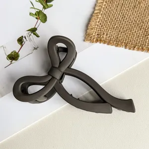 Dunkelgraue matte Schleifen Haarklammer im Detail, elegantes Styling Haaraccessoire.