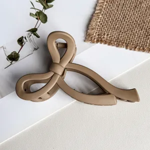 Detailansicht einer matten beigen Schleifen-Haarklammer, elegantes Accessoire zum Stylen.