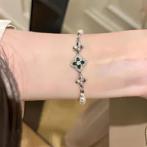 Close-up detail shot of the elegant floral rhinestone and pearl bracelet worn on the wrist.